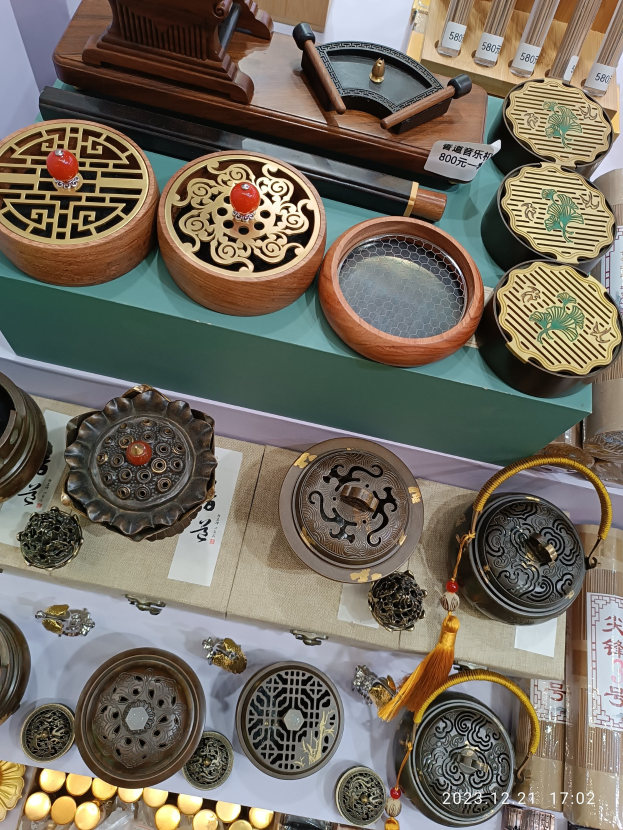 Ein Tisch mit verschiedenen chinesischen Räucherstäbeln, Schachteln, Papieren mit Text und anderen Gegenständen, die likely für ein chinesisches Neujahrsfest arrangiert sind.