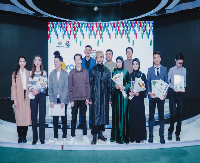 Gruppe von Menschen auf einer Bühne mit Blumensträußen und Urkunden, im Hintergrund ein Banner "Jugend-Solar-Awards 2019"