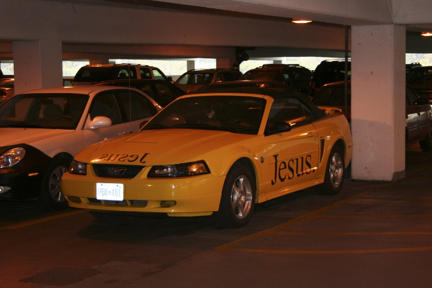 Ein überfüllter Parkplatz mit zahlreichen Autos vor einem Gebäude