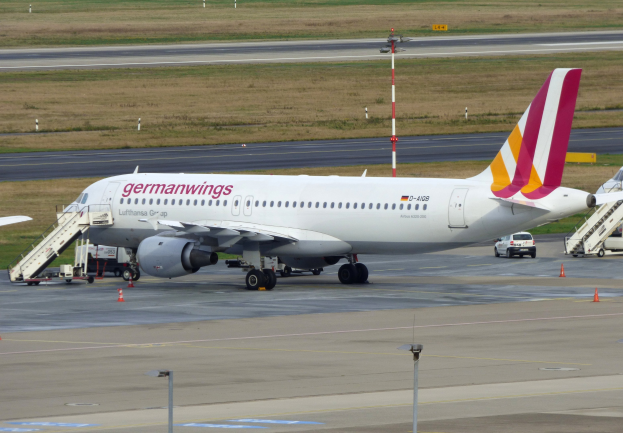 Ein Airbus A320-200 der Germanwings steht auf dem Frankfurter Flughafen, umgeben von Fahrzeugen, Verkehrskegeln, Pfählen und Gras.