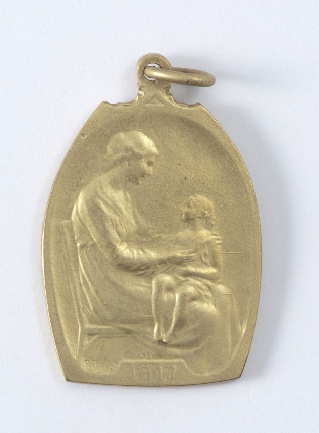 Goldmedaille mit Relief einer Frau in weißem Kleid mit Haarknoten, die ein Kind hält, das bewundernd zu ihr aufschaut, beschriftet mit "Mutter und Kind."