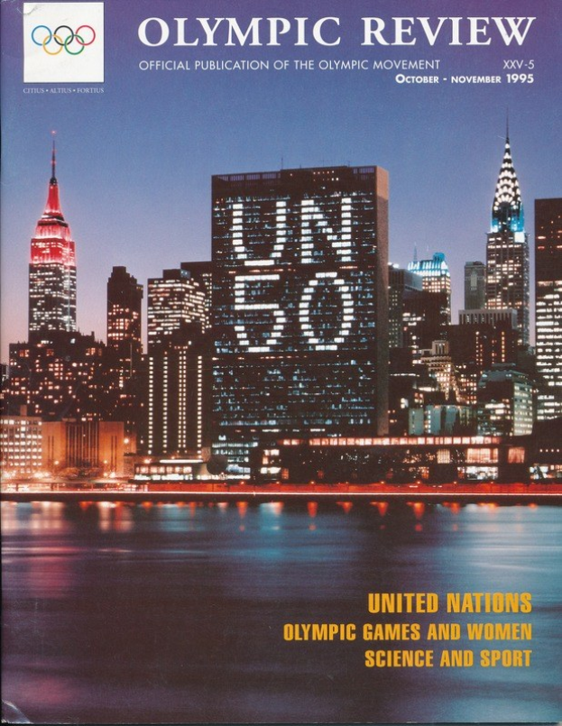 Buch mit dem Titel "Olympische Übersicht Offizielle Veröffentlichung der Olympischen Bewegung" mit einem Stadtbild auf dem Cover, das auf einer flachen Oberfläche platziert ist.