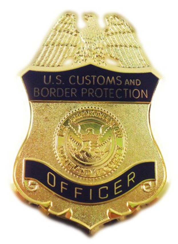 Goldene Marke mit dem Text "U.S. Customs and Border Protection Officer" auf einem weißen Hintergrund.