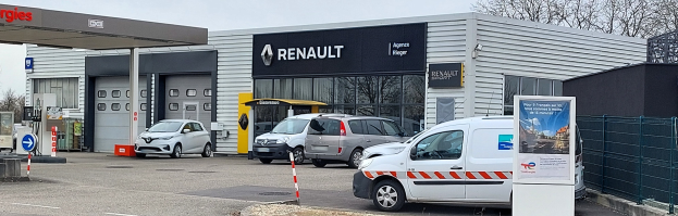 Renault-Vertretung mit parkenden Autos vorne, umgeben von einem Metallzaun.