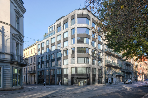 Großes Bürogebäude mit mehreren Fenstern, umgeben von Straßeninfrastruktur, Fahrzeugen, Fußgängern, Bäumen und einem bewölkten Himmel, als das neue Hauptquartier der Firma identifiziert.