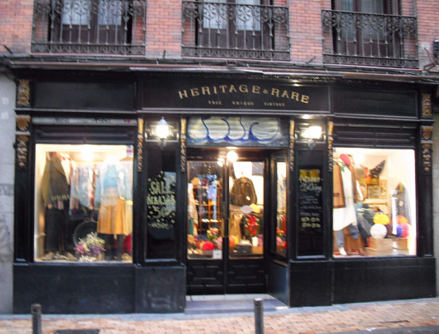 Heritage Boutique in Madrid mit Schaufensterpuppen, Außengeländern und einer Ladenschilder über der Straße.